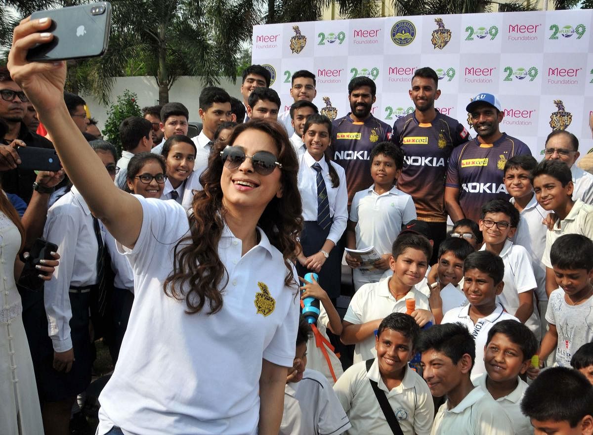 Bollywood actor and Kolkata Knight Riders co-owner Juhi Chawla takes selfie with school students and KKR team players Robin Uthappa, Sandeep Warrier and Prasidh Krishna during a promotional event, in Kolkata, Thursday, Oct. 3, 2019. (PTI Photo)