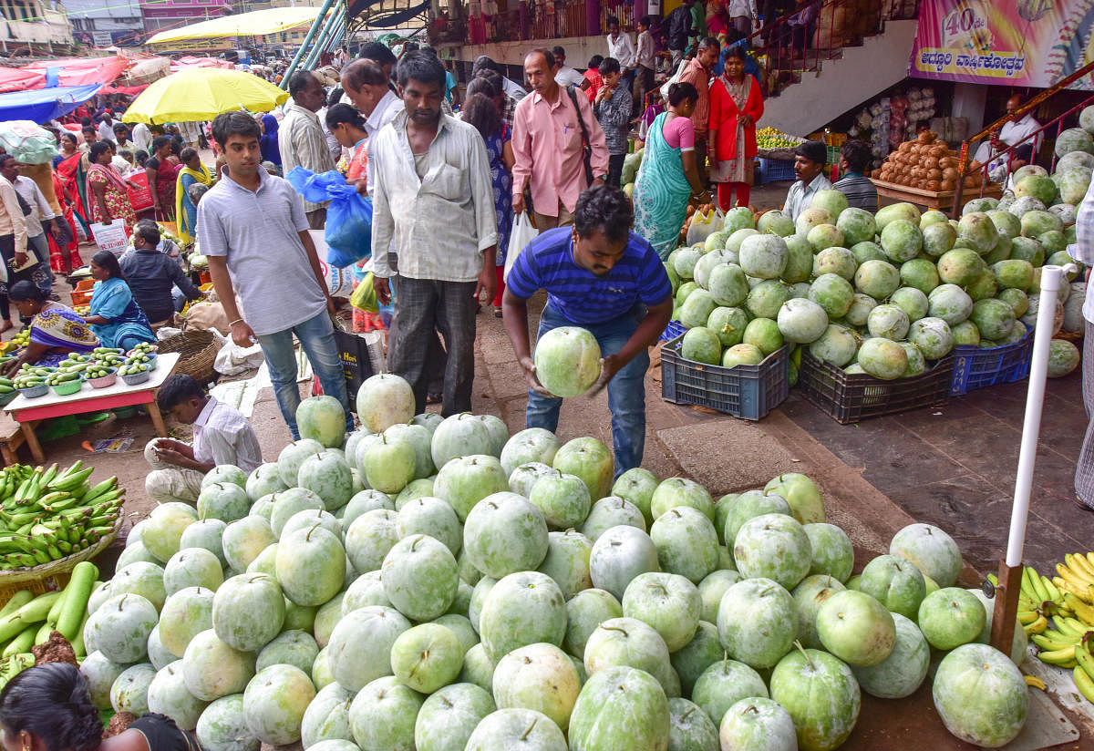 People purchase ash gourd and banana stems ahead of Ayudha Pooja and Vijayadashami festivals at KR market on Friday. The festivals are celebrated on Monday and Tuesday. DH PHOTOs/IRSHAD MAHAMMAD