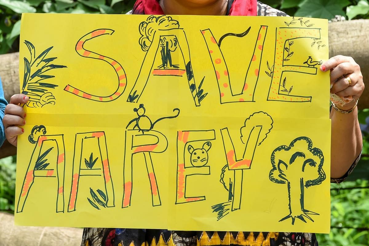 A woman holds a poster as she protests against the destruction of Aarey forest which they call "Mumbai's Amazon", after the government approved cutting down 2,700 trees for constructing a metro train car shed, in Mumbai. (AFP Photo)