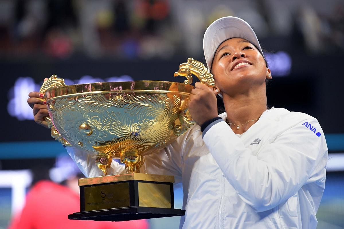 Naomi Osaka of Japan poses with the trophy after winning her women's singles final match against Ashleigh Barty of Australia at the China Open tennis tournament in Beijing. (AFP Photo)