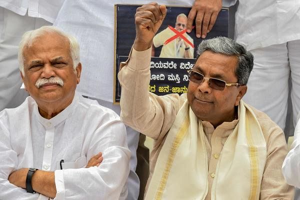 Senior Congress leader and former Chief Minister of Karnataka, Siddaramaiah (R), along with Congress legislators and leaders stage a demonstration at the Gandhi statue in Vidhana Soudha in Bangalore on September 18, 2019, against Bharatiya Janata Party (BJP) government for the delay in providing relief to the flood victims. (Photo / AFP)