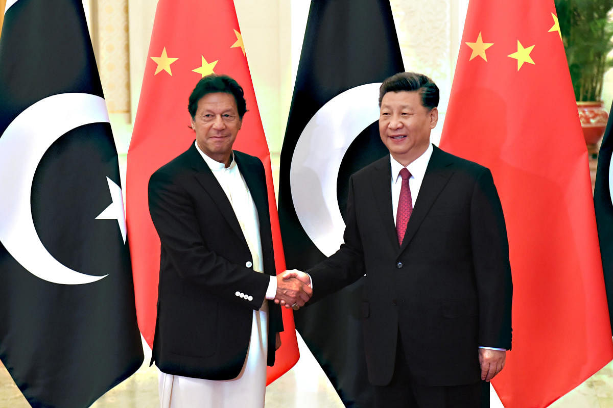 E China's President Xi Jinping shakes hands with Pakistan's Prime Minister Imran Khan. (Reuters Photo)