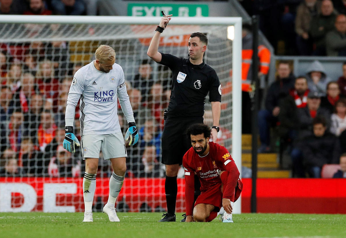Referee Chris Kavanagh gestures after Liverpool's Mohamed Salah goes down due to an injury. REUTERS