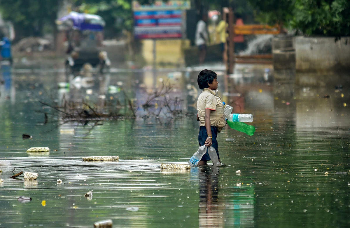 A rag picker collects plastic drinking bottles floating on floodwaters after water levels receded at Rajendra Nagar area, in Patna, Sunday, Oct. 06, 2019. (PTI Photo)