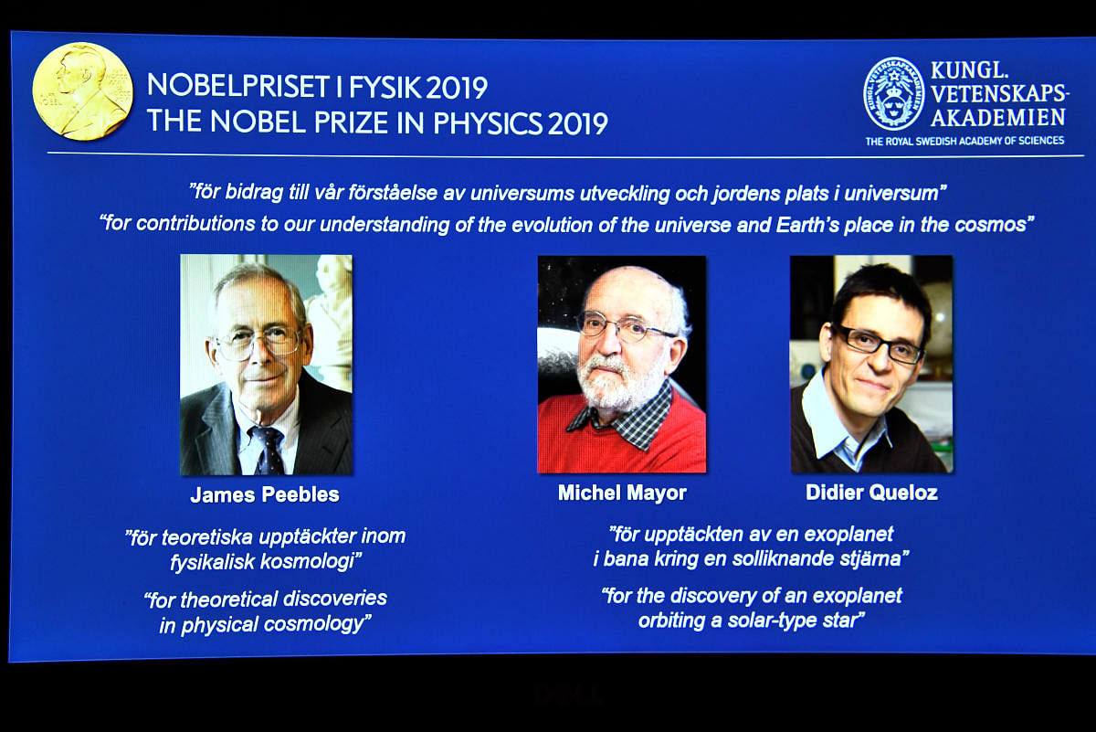 A screen displays the portraits of the laureates of the 2019 Nobel Prize in Physics (L-R) James Peebles, Michel Mayor and Didier Queloz, during a news conference at the Royal Swedish Academy of Sciences in Stockholm, Sweden, October 8, 2019. (Claudio Bresciani/TT News Agency/via REUTERS)