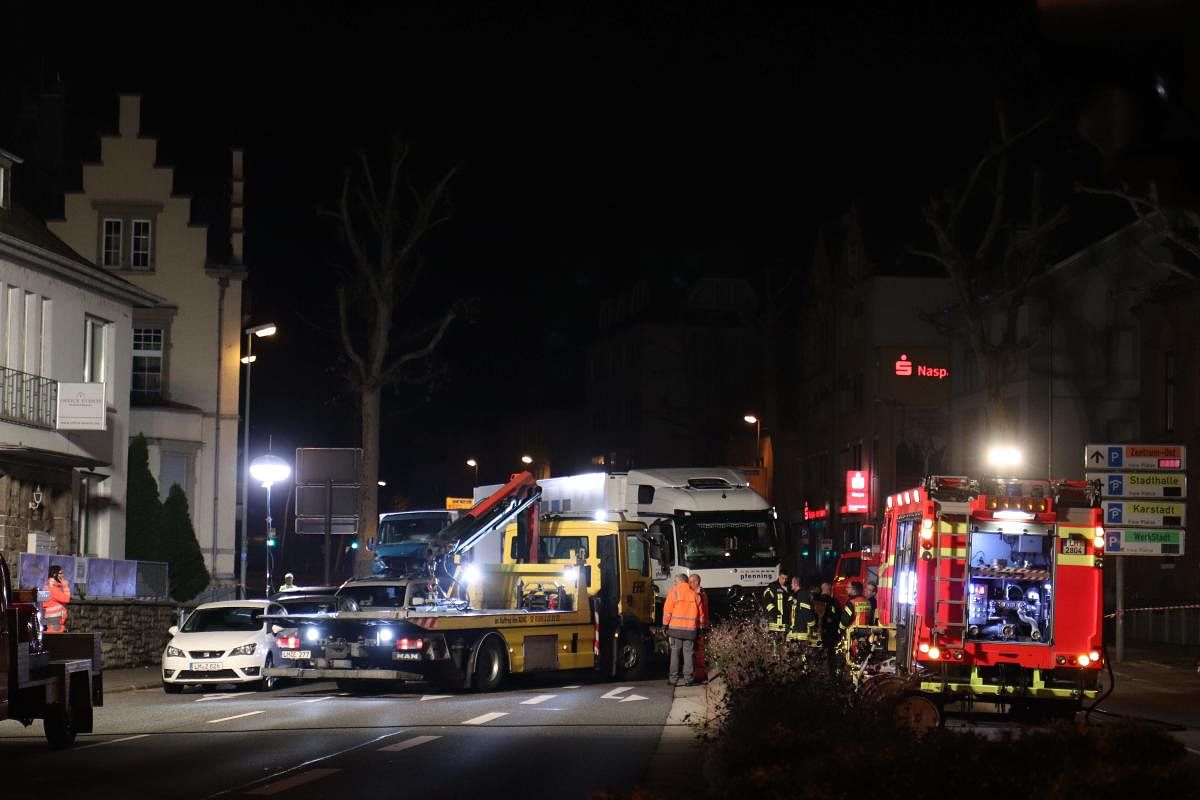 Police cars and an ambulance stand on early October 8, 2019 next to the truck that ploughed into several cars on late October 7 in the centre of the German city of Limburg. AFP