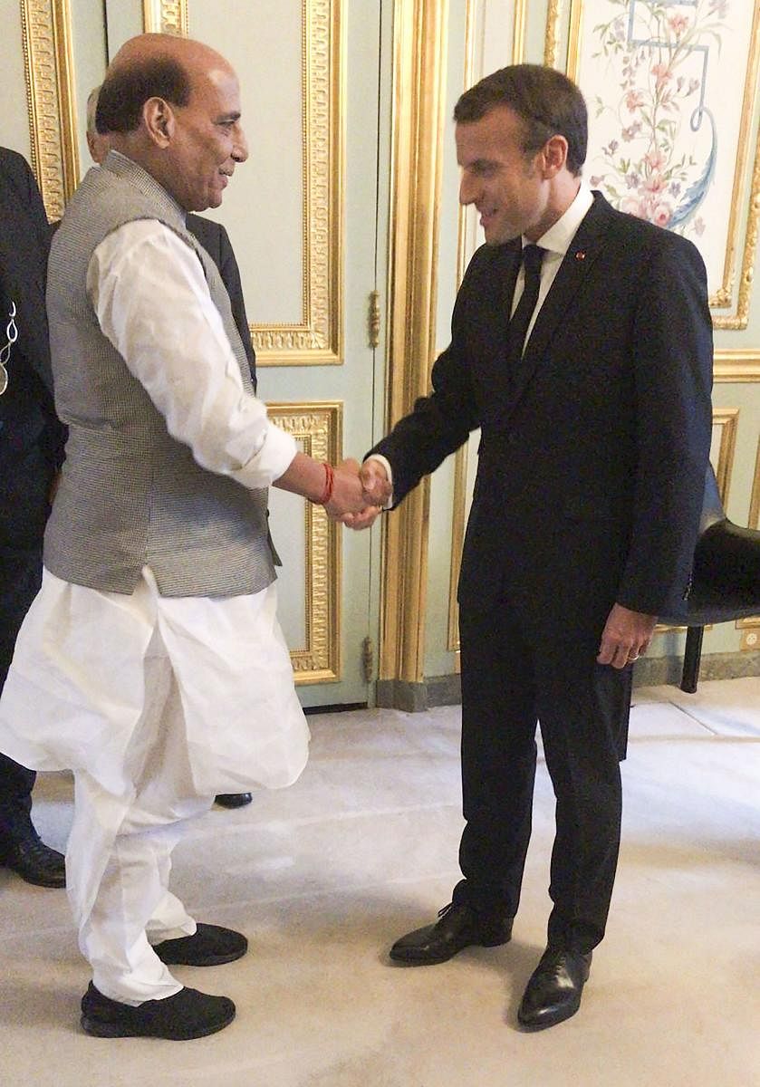 Union Defence Minister Rajnath Singh shakes hands with French President Emmanuel Macron. (PTI Photo)