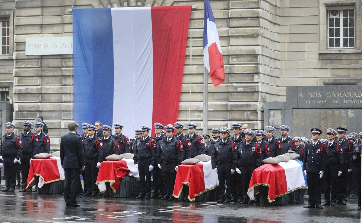French President Emmanuel Macron stands in front of coffins during a ceremony at The Prefecture de Police de Paris (Paris Police Headquarters) in Paris on October 8, 2019, held to pay respects to the victims of an attack at the prefecture on October 4, 2019. AFP