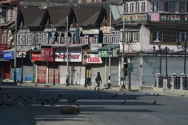 In this file photo taken on September 8, 2019 an Indian paramilitary trooper patrols along an empty street during a strict curfew in Srinagar. (PTI photo)