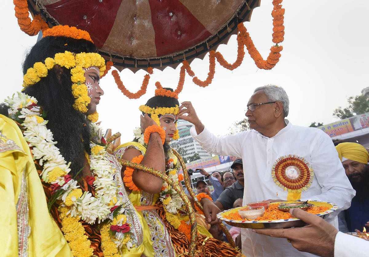 Bihar Chief Minister Nitish Kumar applies 'tilak' on the forehead of an artist dressed as Lord Ram during Dussehra celebrations at Gandhi Maidan in Patna, Tuesday, Oct. 8, 2019. Photo/PTI