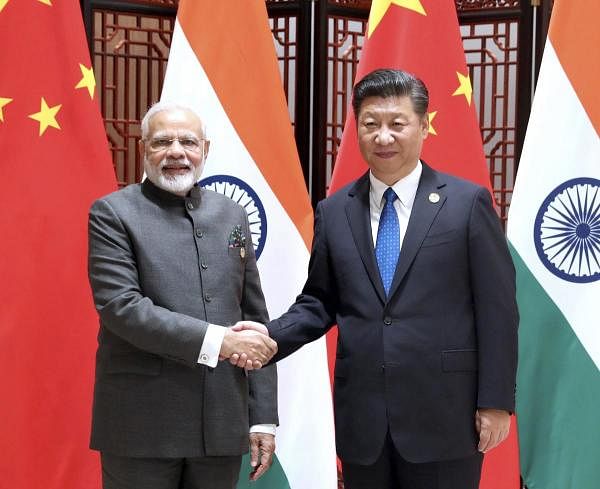 In this photo released by China's Xinhua News Agency, Indian Prime Minister Narendra Modi, left, and China's President Xi Jinping shake hands as they pose for a photo during a meeting on the sidelines of the BRICS Summit in Xiamen in southeastern China's Fujian Province. (AP photo)