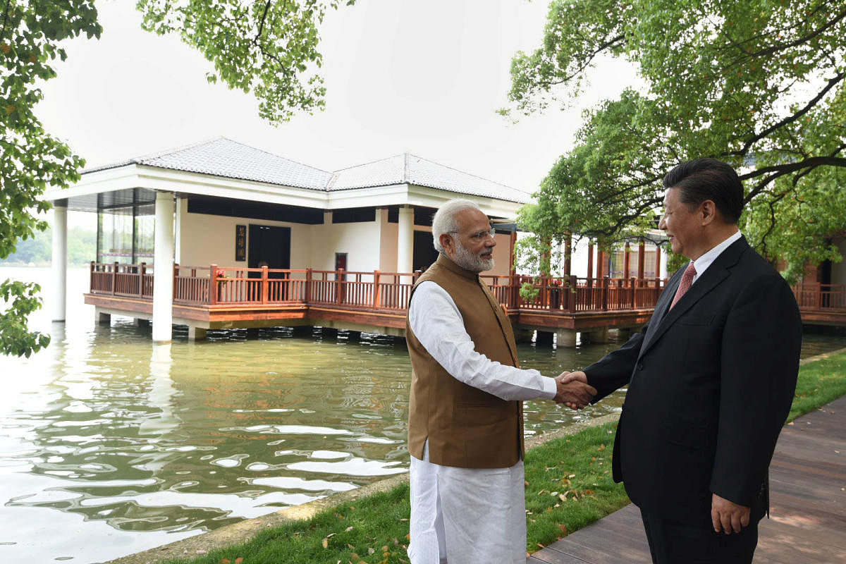 Chinese President Xi Jinping shakes hands with India's Prime Minister Narendra Modi as they walk along the East Lake in Wuhan, China, April 28, 2018. (Photo by Reuters)