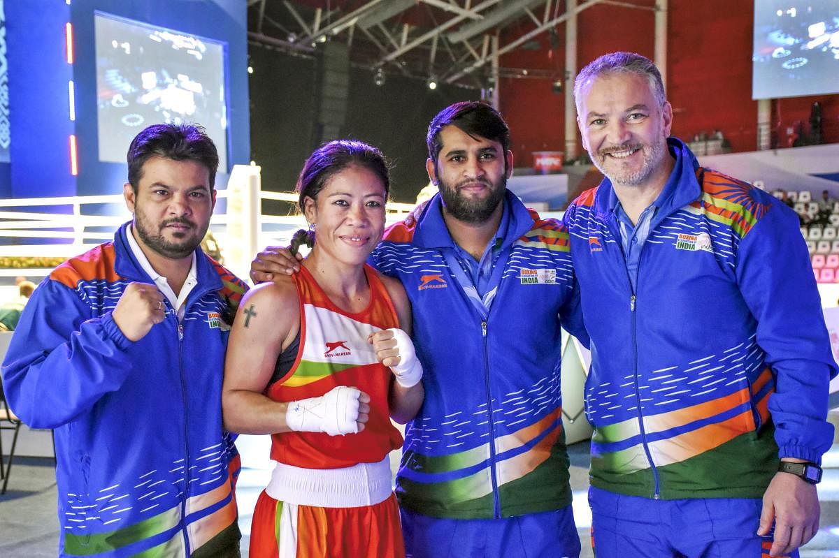 India's Mary Kom (51kg) with her coaches Raffaele Bergamasco (R) and Chhote Lal (R) after winning her bout against Colombia's Valencia Victoria and advancing to semi-finals at AIBA's Women's World Championship, in Ulan-Ude, Russia, Thursday, Oct. 10, 2019