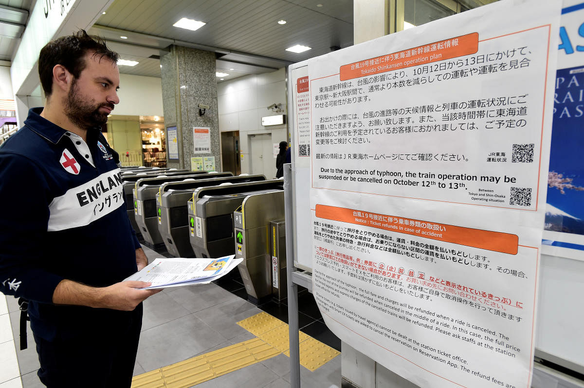 An England rugby supporter reads a travel warning sign at Hamamatsu railway station, regarding Typhoon Hagibis and possible train suspensions and cancellations in Hamamatsu, Japan, October 10, 2019. Reuters