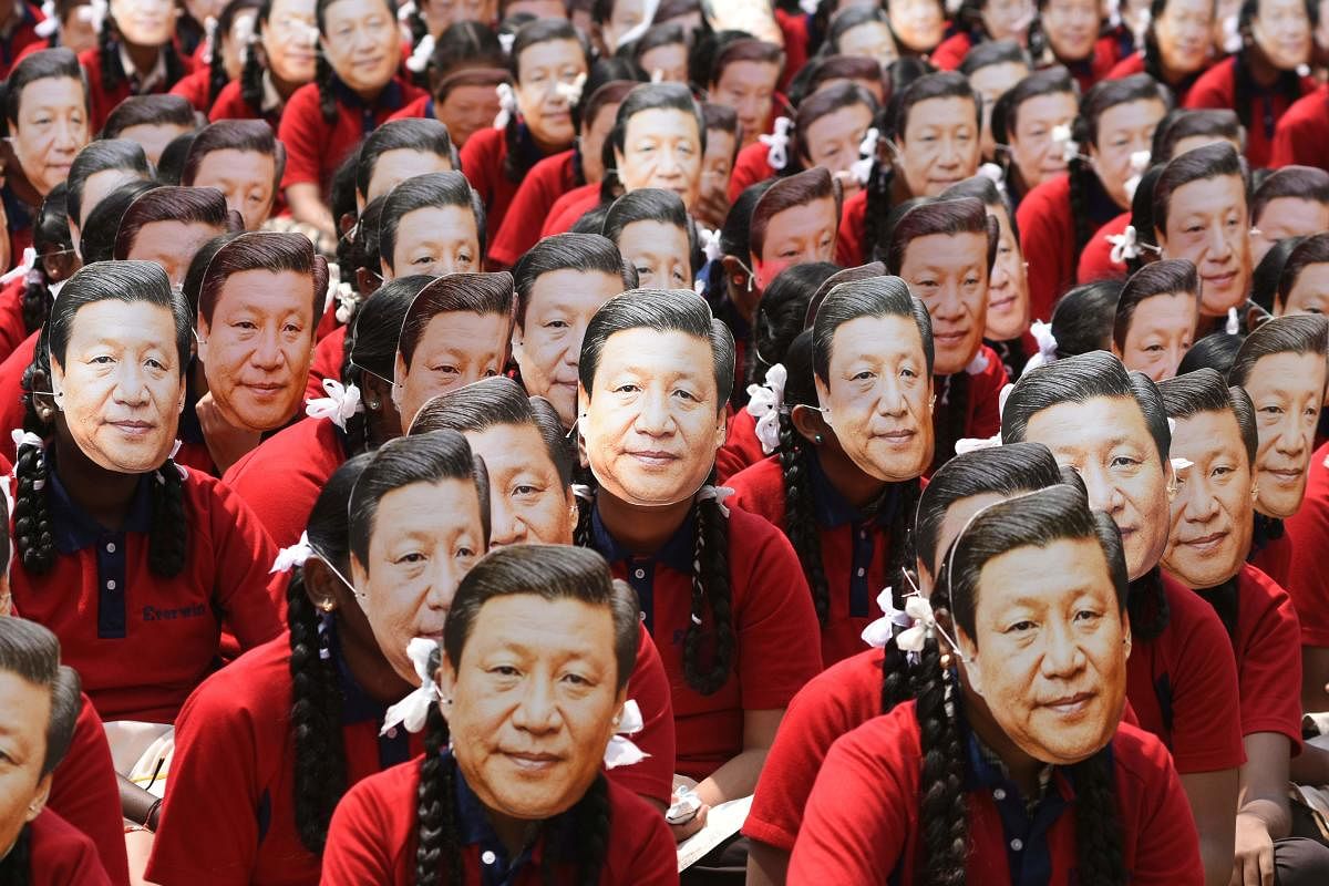 Schoolchildren wear masks of China's President Xi Jinping in Chennai on Thursday. AFP