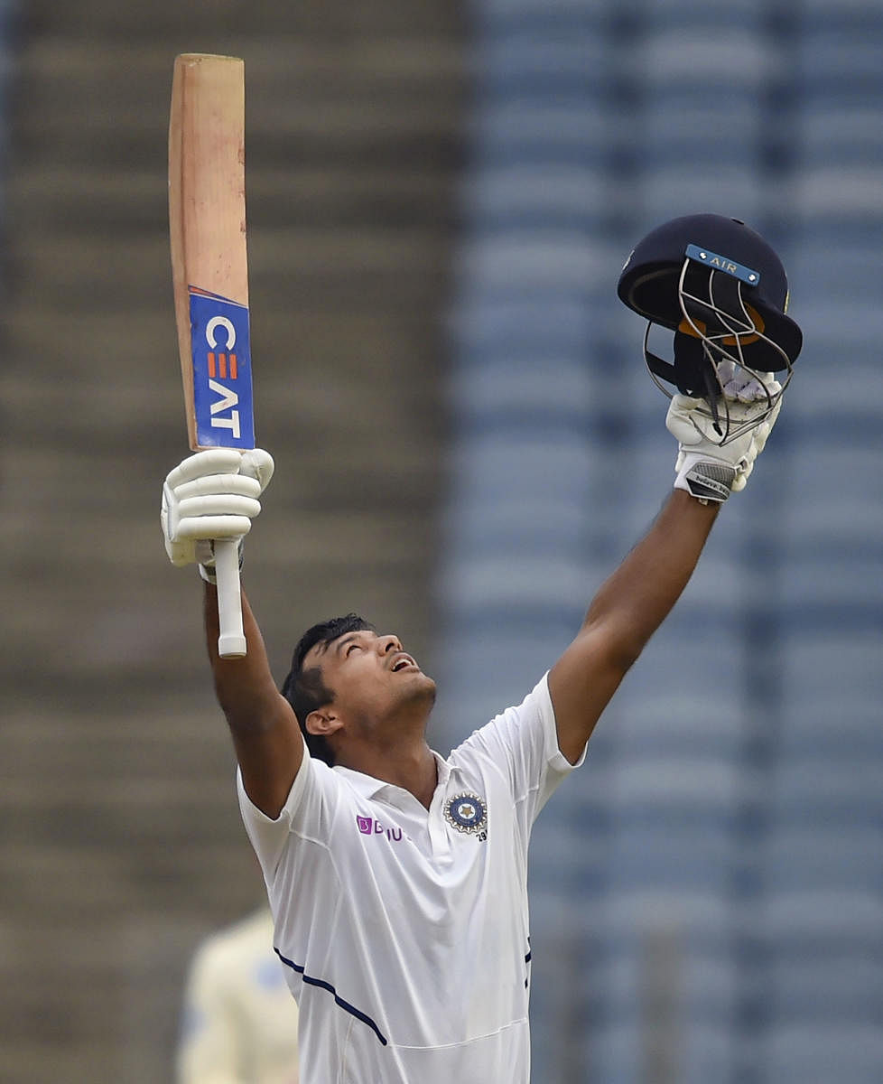 Opener Mayank Agarwal celebrates after reaching his century on the opening day of the second Test against South Africa in Pune on Thursday. PTI