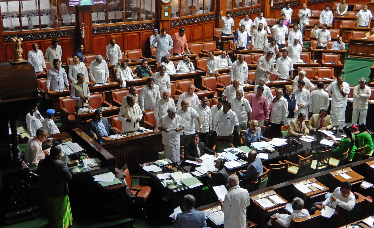 Members of the Opposition stage a protest, demanding a discussion on the state's flood situation, in the Assembly on Thursday.