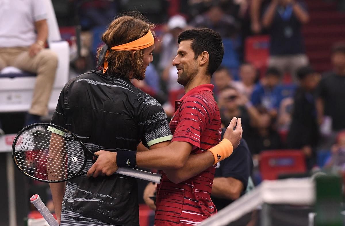 Stefanos Tsitsipas of Greece (L) speaks with Novak Djokovic of Serbia after winning their men's singles quarter-final match at the Shanghai Masters tennis tournament in Shanghai on October 11, 2019. (AFP)
