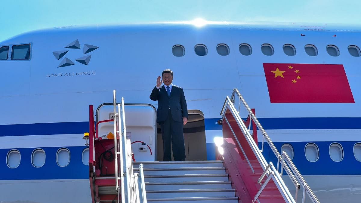 China's President Xi Jinping waves as he arrives in Chennai, to attend a summit with India's Prime Minister Narendra Modi at the World Heritage Site of Mahabalipuram from October 11 to 12. (Photo by Handout / Indian Ministry of External Affairs (MEA) / AF