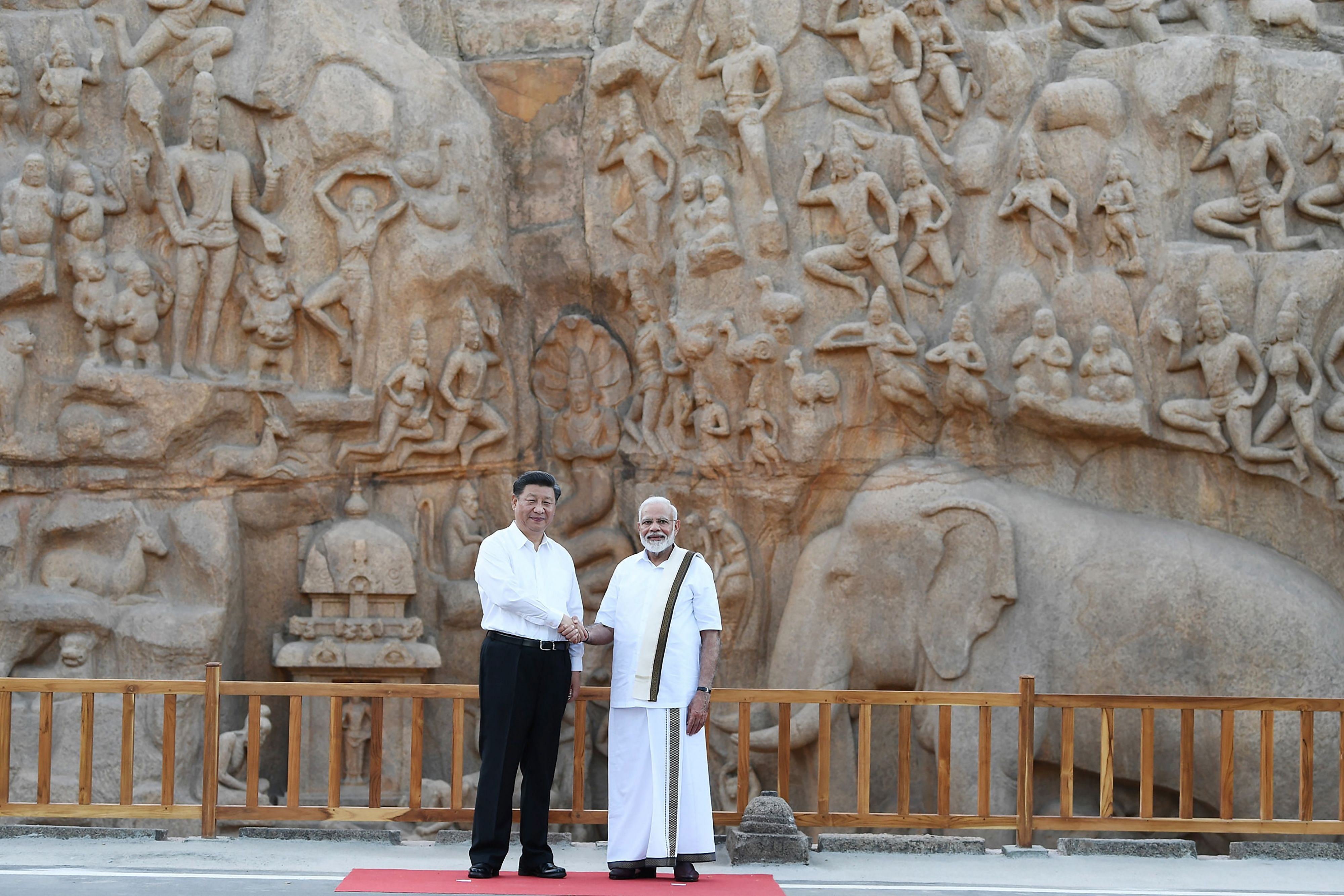 Prime Minister Narendra Modi (R) shakes hands with Chinese President Xi Jinping during their visit at at Arjuna's Penance, ahead of the summit at the World Heritage Site of Mahabalipuram in Tamil Nadu. (AFP Photo)