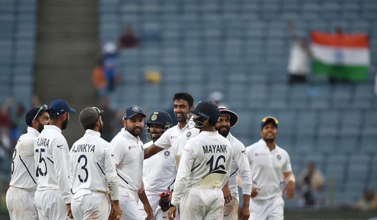Indian cricket players stand in huddle as they celebrate after the wicket of South Africa's batsman Keshav Maharaj during the third day of play of the second test cricket match between India and South Africa, at the Maharashtra Cricket Association Stadium in Pune on October 12, 2019. (Photo by PUNIT PARANJPE / AFP) 