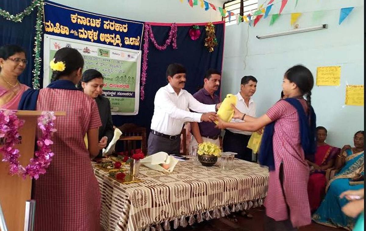 Deputy Commissioner G Jagadeesha hands over a gift to a student at National Girls’ Day celebrations organised at State Home in Udupi. 