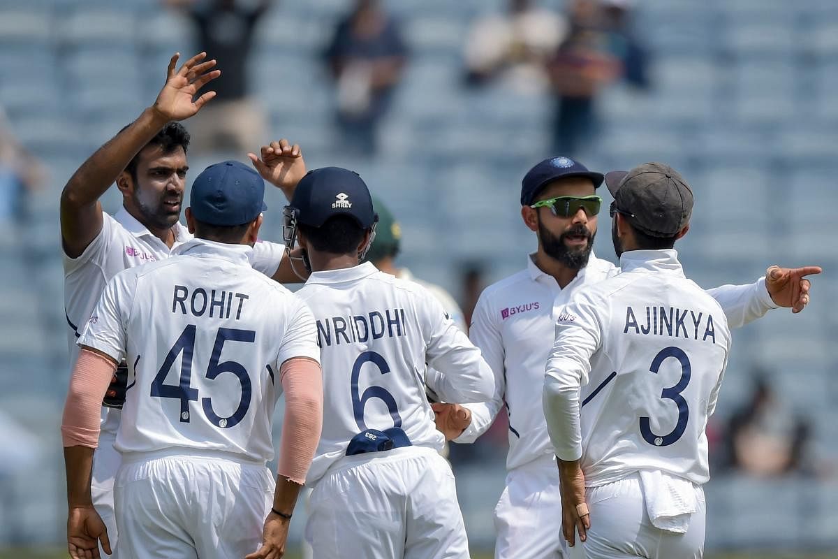 India's Ravichandran Ashwin (L) celebrates with teammates after dismissing South Africa's Quinton de Kock during the third-day play of the second Test cricket match between India and South Africa. (AFP Photo)