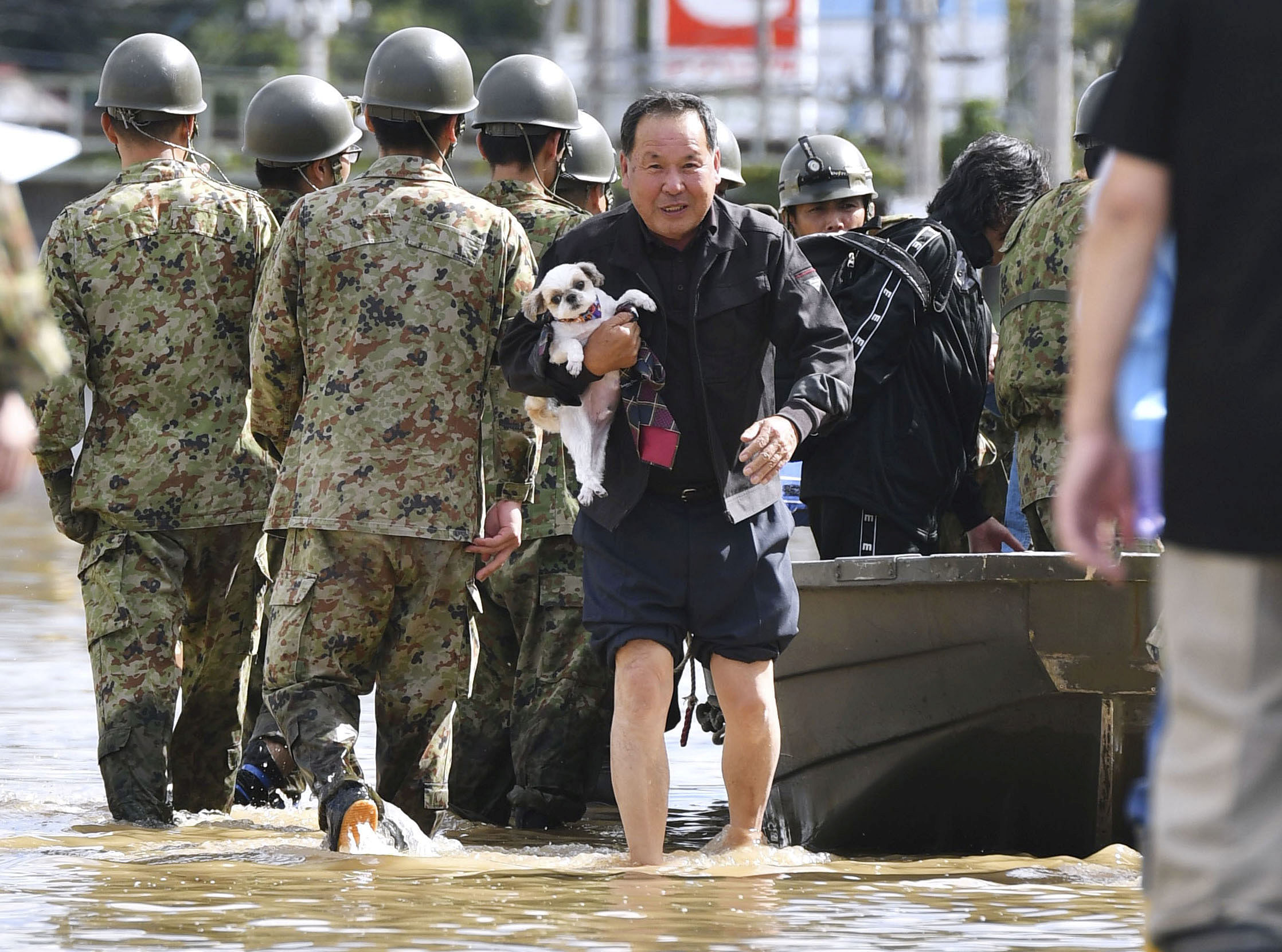 A local resident carrying his pet dog evacuates from an area flooded by the Abukuma river, caused by Typhoon Hagibis, in Motomiya, Fukushima prefecture, Japan. (Reuters Photo)