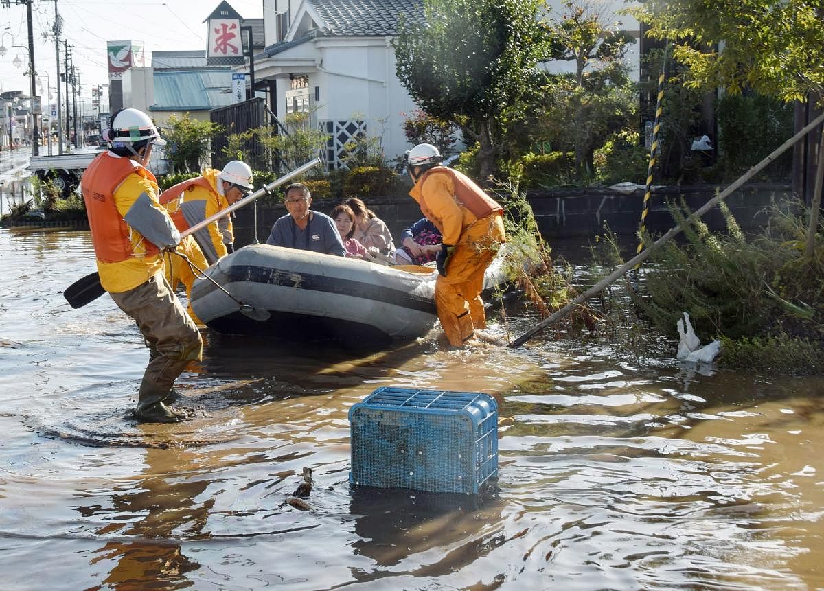 Fire department workers evacuate residents from a flooded area in Date, Fukushima prefecture on October 13, 2019, one day after Typhoon Hagibis swept through central and eastern Japan. AFP Photo