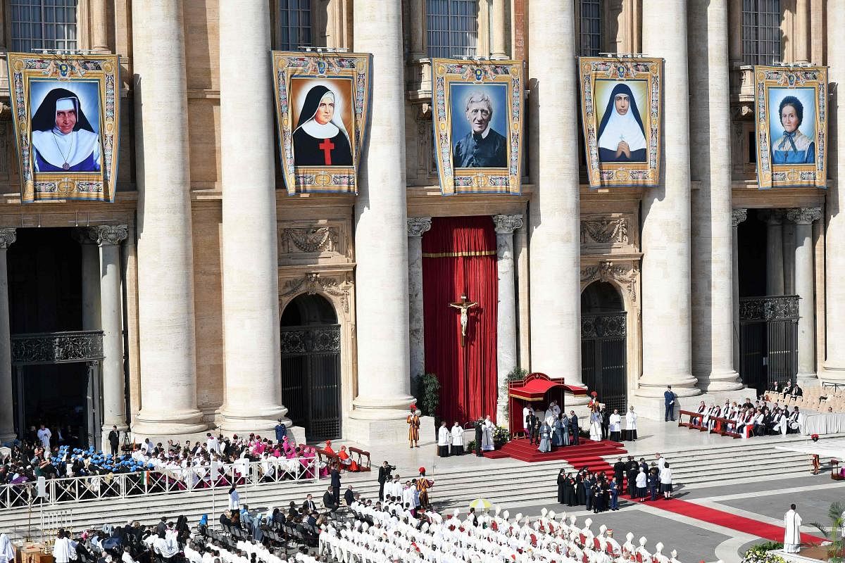 Tapestry of the new Saint (from L) Brazilian Dulce Lopes Pontes, Italian Giuseppina Vannini, English John Henry Newman, Indian Maria Teresa Chiramel Mankidiyan and Swiss Margarita Bays are displayed durint their Canonization Mass, on October 13, 2019 In Saint Peter's square at the Vatican. (Photo by Alberto PIZZOLI / AFP)