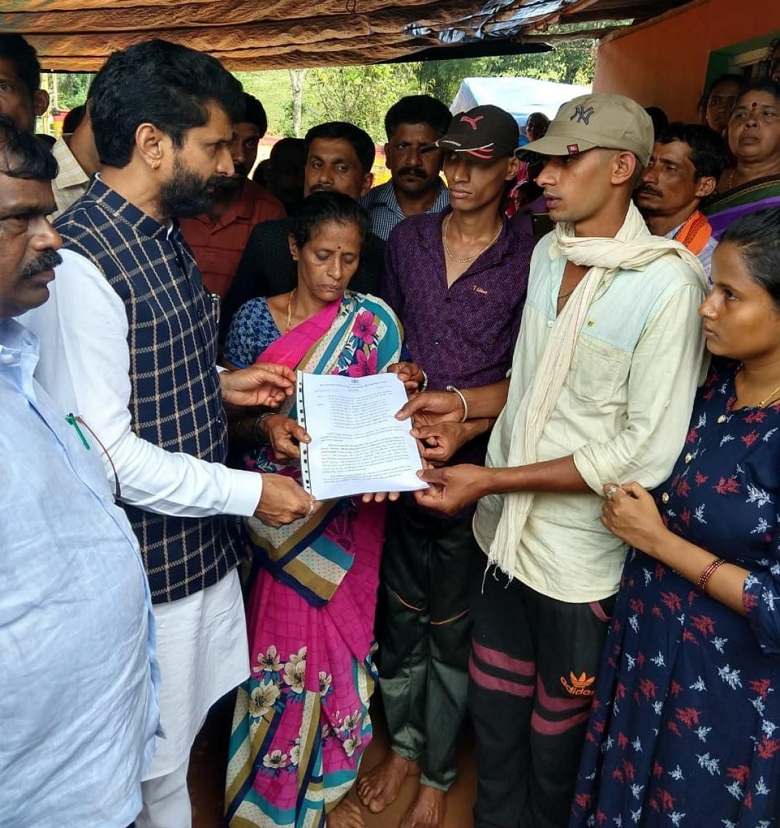 District In-charge Minister C T Ravi hands over the compensation sanction letter to the family of farmer Chandre Gowda, who committed suicide at S K Megal in Kalasa recently.