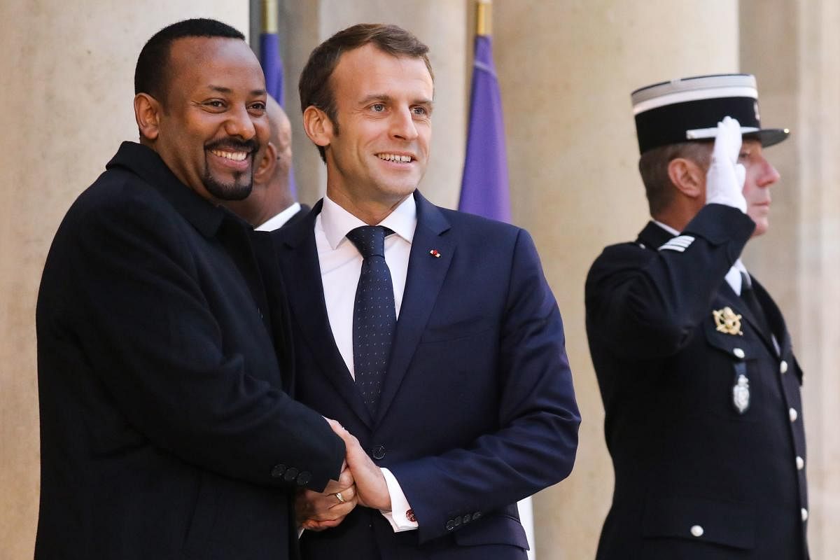 French President Emmanuel Macron (R) shakes hands with Ethiopian Prime Minister Abiy Ahmed. AFP