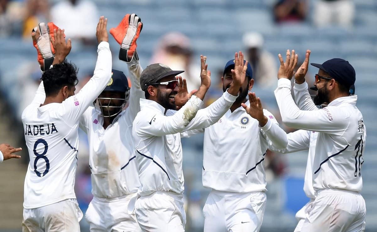 India’s deputy Ajinkya Rahane (centre) celebrates with captain Virat Kohli (right) after taking a catch to dismiss South Africa batsman Temba Bavuma on the fourth day of the second Test in Pune on Sunday. AFP