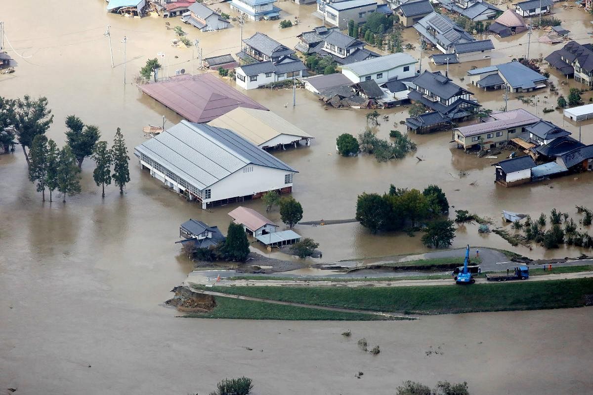 This aerial view shows flooded homes beside the collapsed bank of the Chikuma river in Nagano, Nagano prefecture on October 13, 2019, one day after Typhoon Hagibis swept through central and eastern Japan. AFP