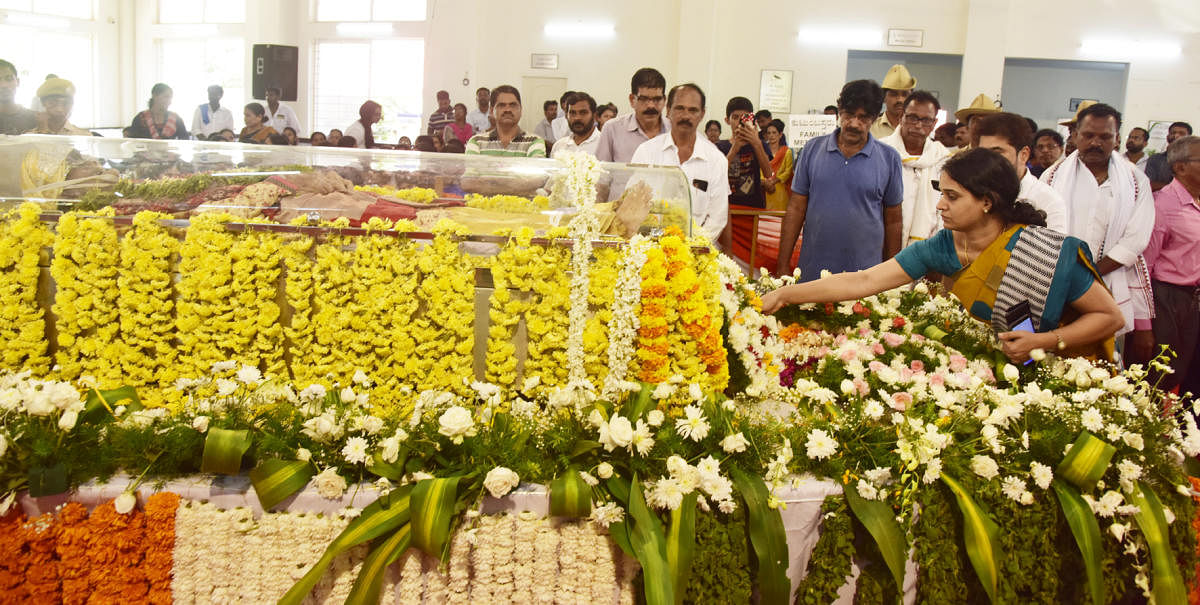 Deputy Commissioner Sindhu B Rupesh places a wreath on the mortal remains of saxophonist Kadri Gopalnath, before the last rites in Mangaluru on Monday. DH photo