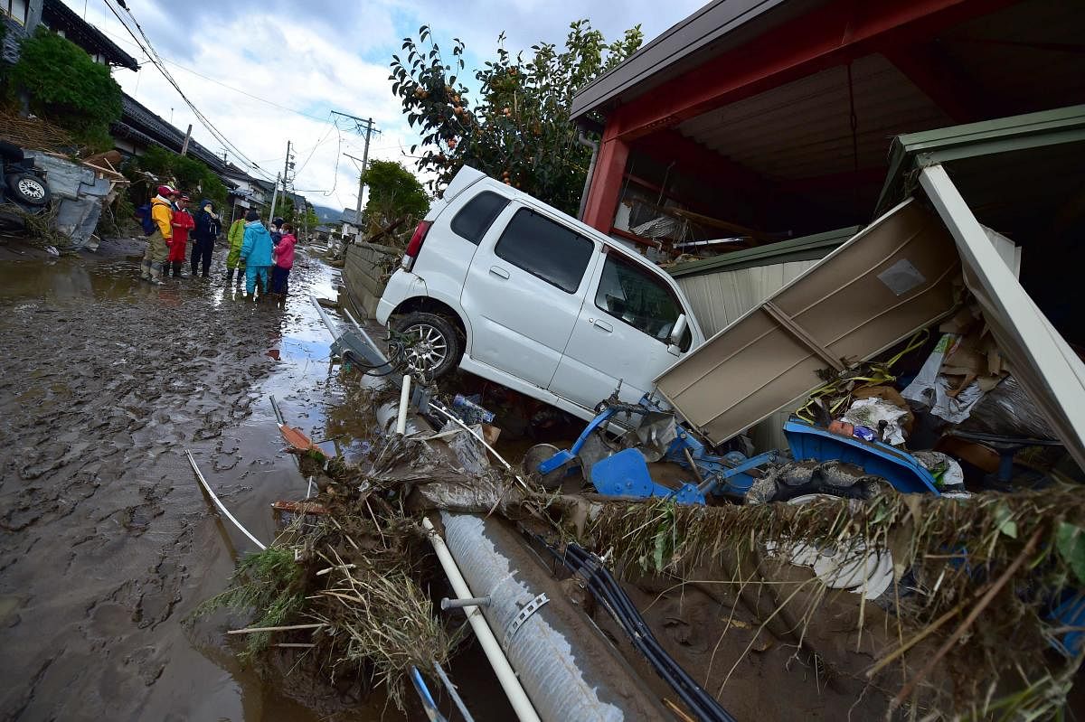 A car sits next to a badly damaged home in Nagano on October 15, 2019, after Typhoon Hagibis hit Japan on October 12 unleashing high winds, torrential rain and triggered landslides and catastrophic flooding. (AFP)
