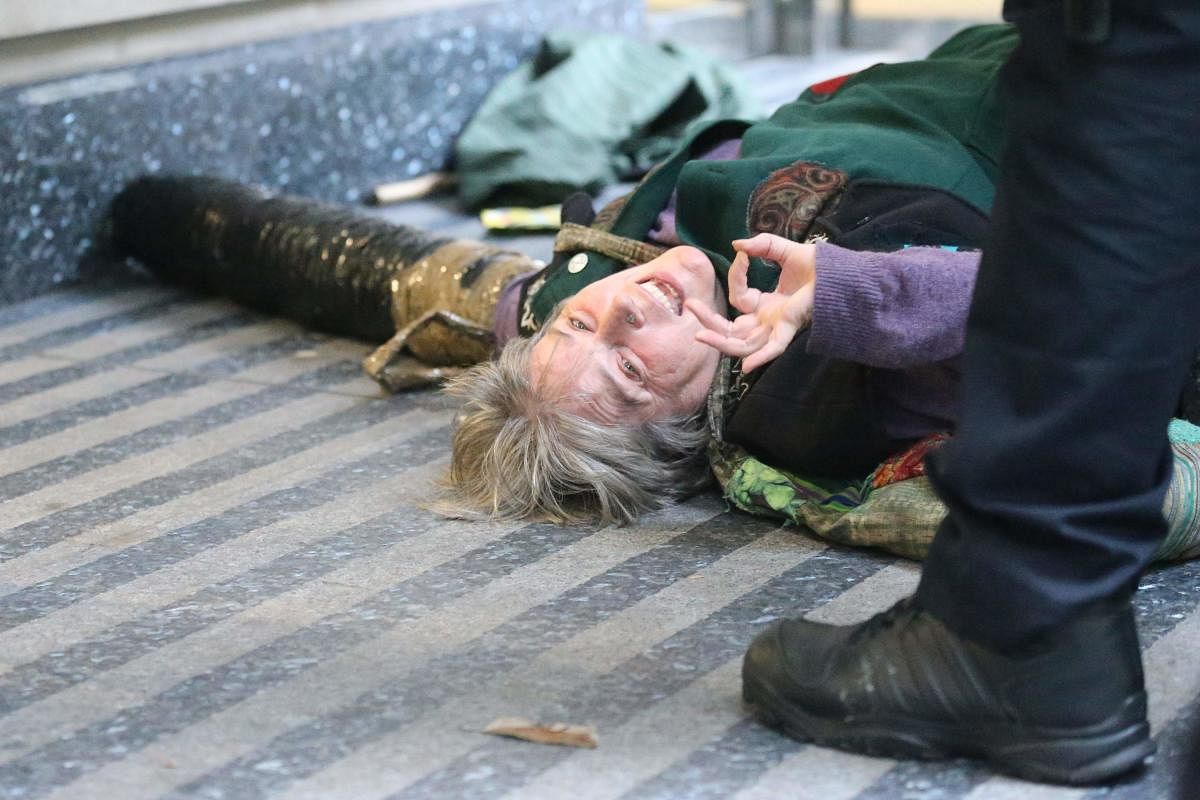 An activist from the Extinction Rebellion climate action movement lies on the floor locked on to the entrance of the building housing the government's Department for Transport in central London on October 15, 2019 as part of Extinction Rebellion's Autumn