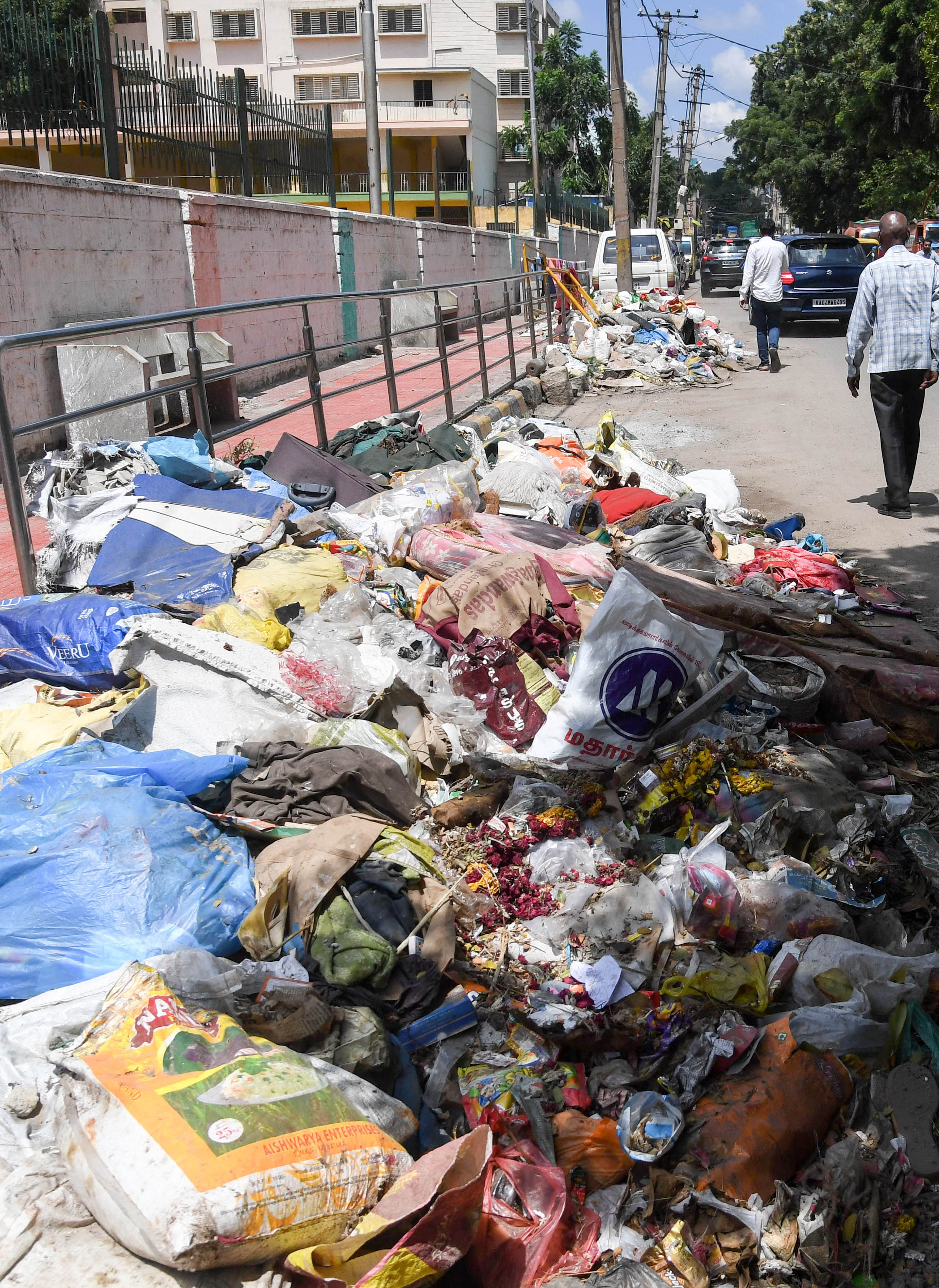 Unclear garbage, which cover the road, in front of Dr.B.R. Ambedkar of Law College, at Srirampura 5th Main road, in Bengaluru on Monday. (DH Photo/ B H Shivakumar)