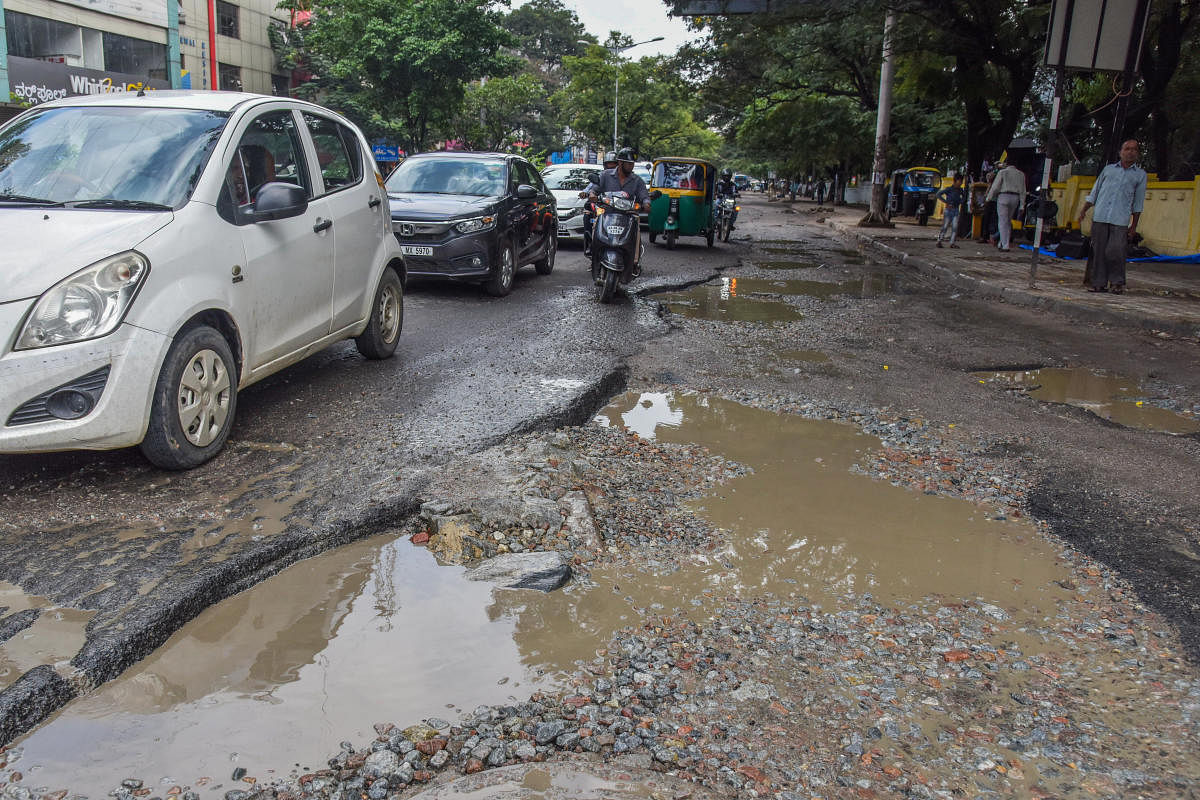 The potholes are getting deeper and bigger on this arterial road, near the KSRTC head office and Shantinagar bus terminal. Thousands of vehicles use this stretch, and no one is doing a thing about the hazards. DH photos by S K Dinesh and Pushkar