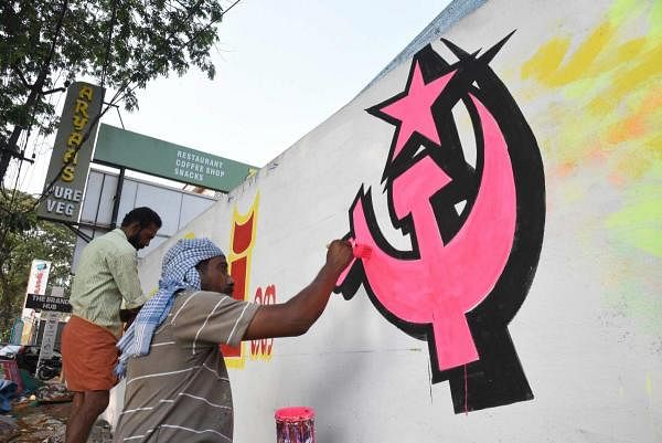 Workers paint a wall for an LDF candidate ahead of the Lok Sabha polls, in Kochi. (PTI photo)