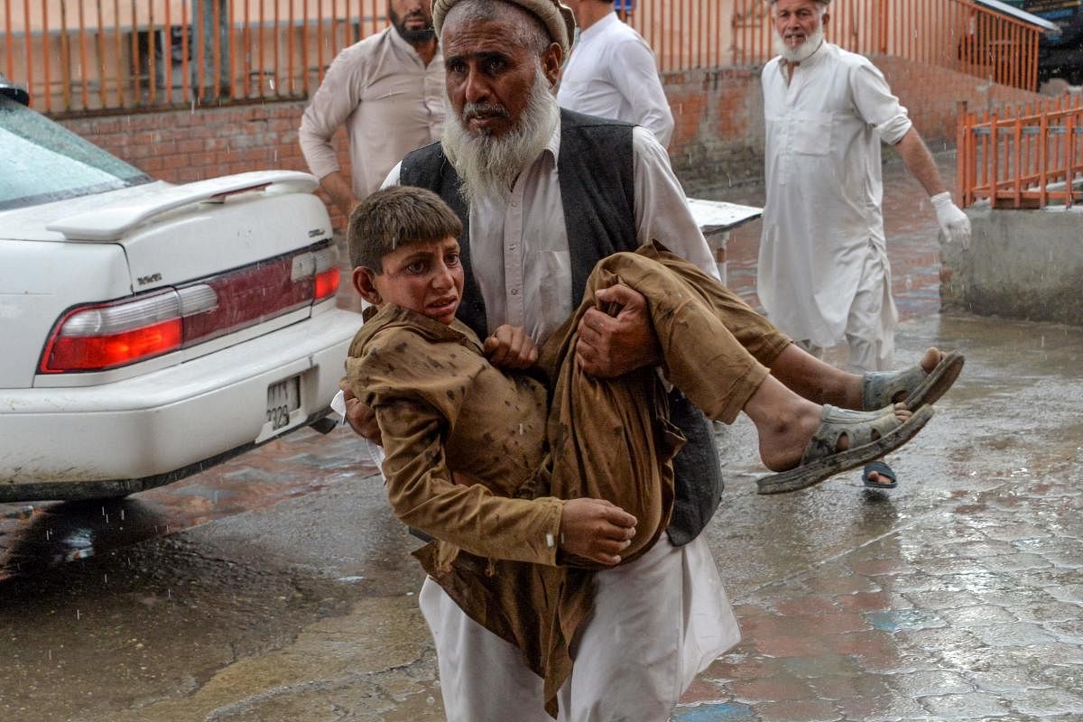 A volunteer carries an injured youth to hospital, following a bomb blast in Haska Mina district of Nangarhar Province on October 18, 2019. AFP Photo