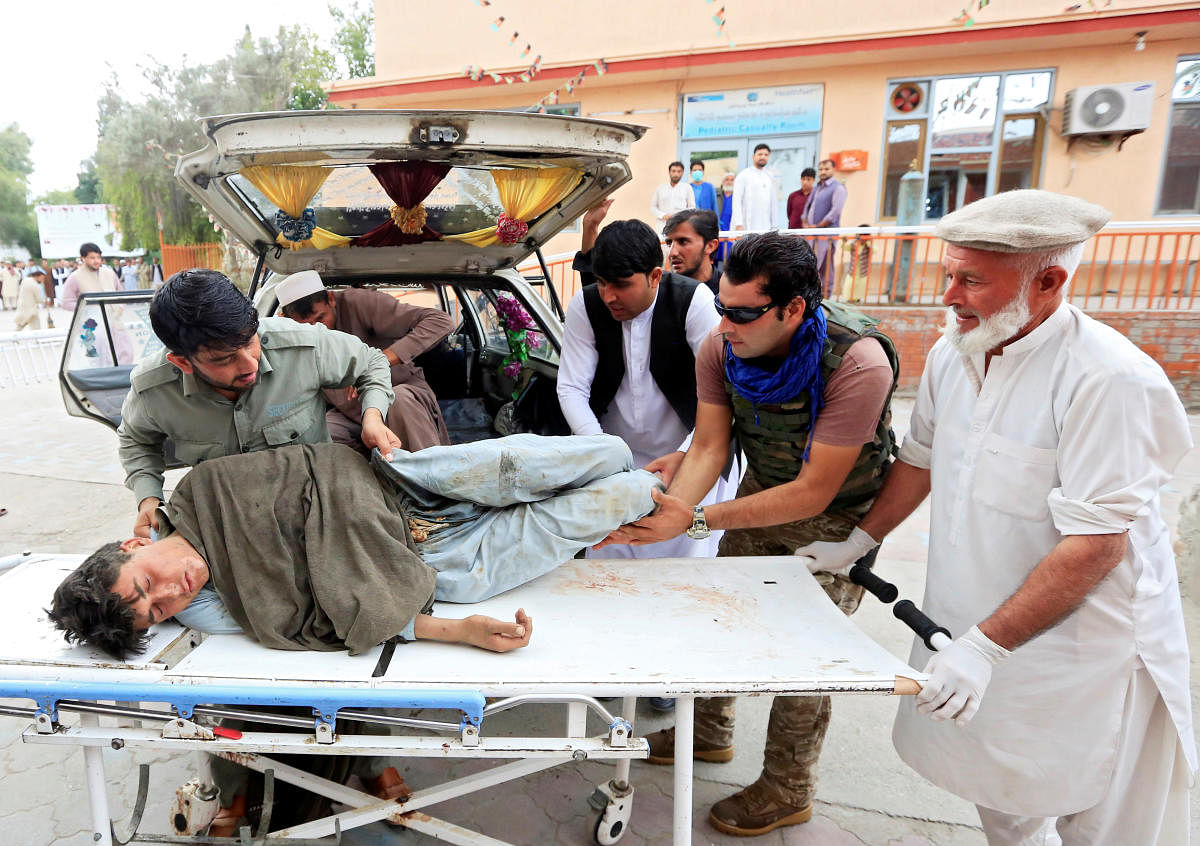 Men carry an injured person to a hospital after a bomb blast at a mosque, in Jalalabad (Reuters Photo)