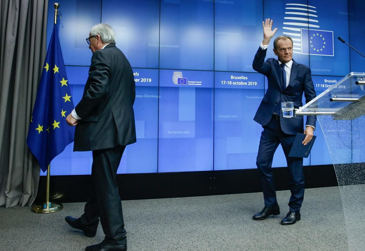 European Council President Donald Tusk (R) and European Commission President Jean-Claude Juncker depart after addressing media representatives at a press conference during a European Union Summit at European Union Headquarters in Brussels on October 18, 2019. AFP