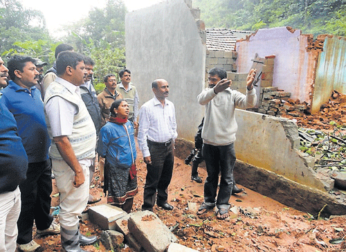 MLA  Appachu Ranjan inspects the houses that were damaged due to heavy rainfall, at Mangaladevi Nagara in Madikeri, on Monday. dh photo