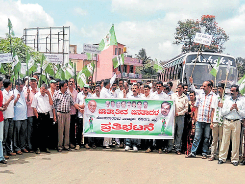 JD(S) workers stage road block at Vivekananda Circle in Somwarpet on Monday. DH photo