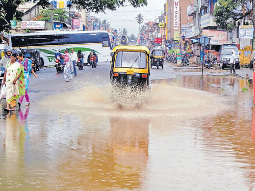 Splashy ride: Roads in Kushalnagar, Kodagu district, were waterlogged following heavy rains for more than an hour on Sunday. DH Photo