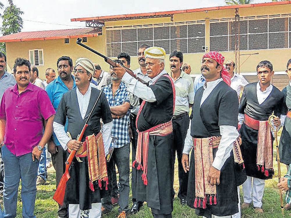 Kodava Samaja President Gopal Thimmaiah inaugurates Kodava Samskrithika Dina and Puthari Kolmand Namme by taking aim at coconuts, at Ponnampet on Monday. DH photo