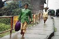 Its Raining: Women workers rush to seek shelterin Kushalnagar on Saturday. DH photo