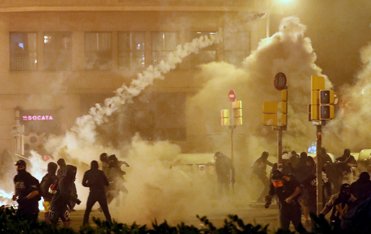 Catalan demonstrators throw back to the police a tear gas canister officer during Catalonia's general strike, in Barcelona, Spain, October 18, 2019. REUTERS/Jon Nazca