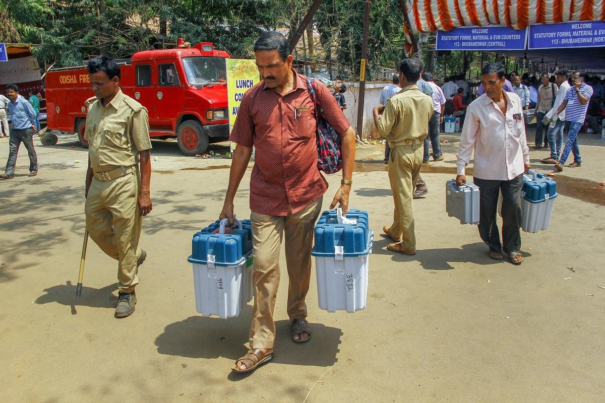Polling officials leave after collecting EVMs and other election material for the third phase of the 2019 Lok Sabha elections, at a distribution centre, in Bhubaneswar.